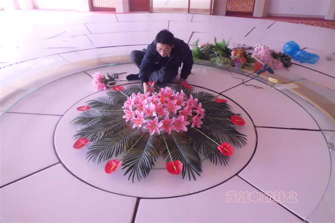 小伙在为电动餐桌玻璃转盘插花